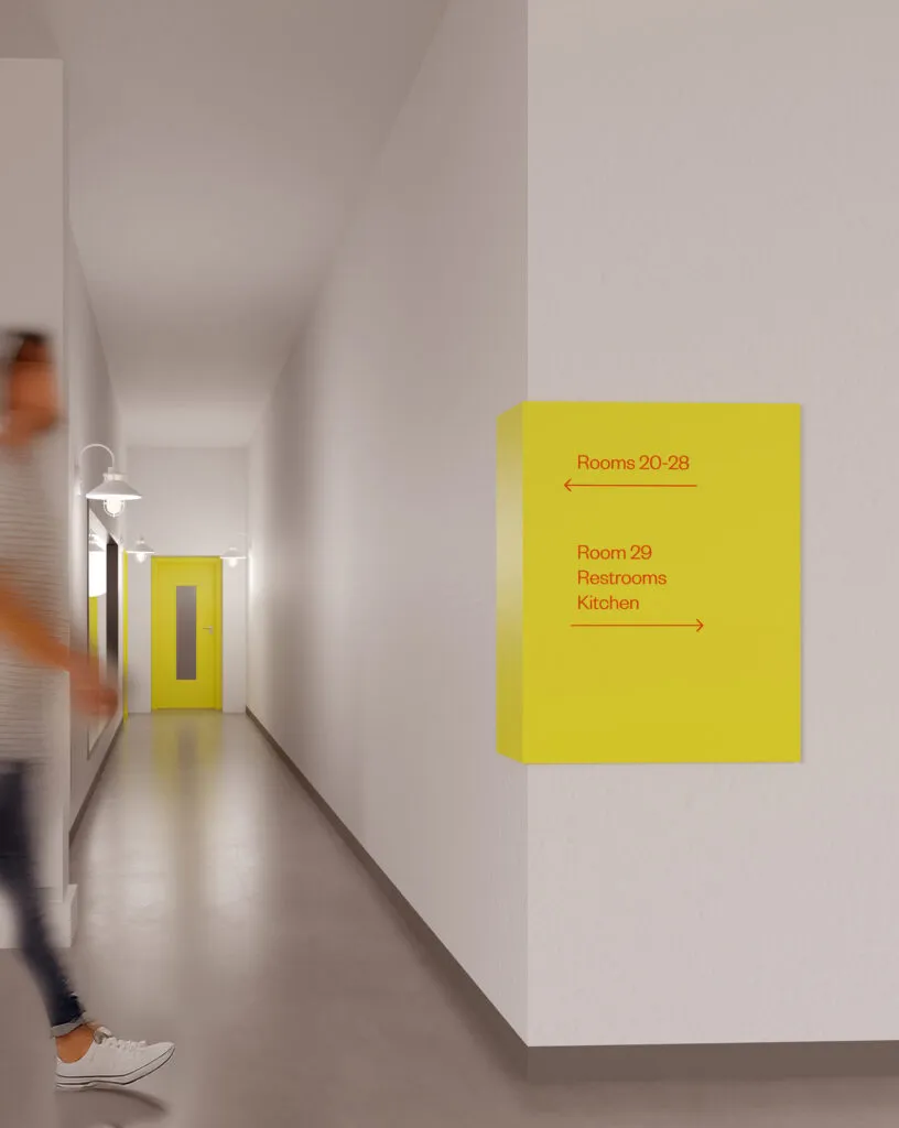 A yellow wall directional in an Asian Arts hallway