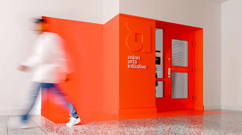 Gallery entrance with painted wall graphic in orange
