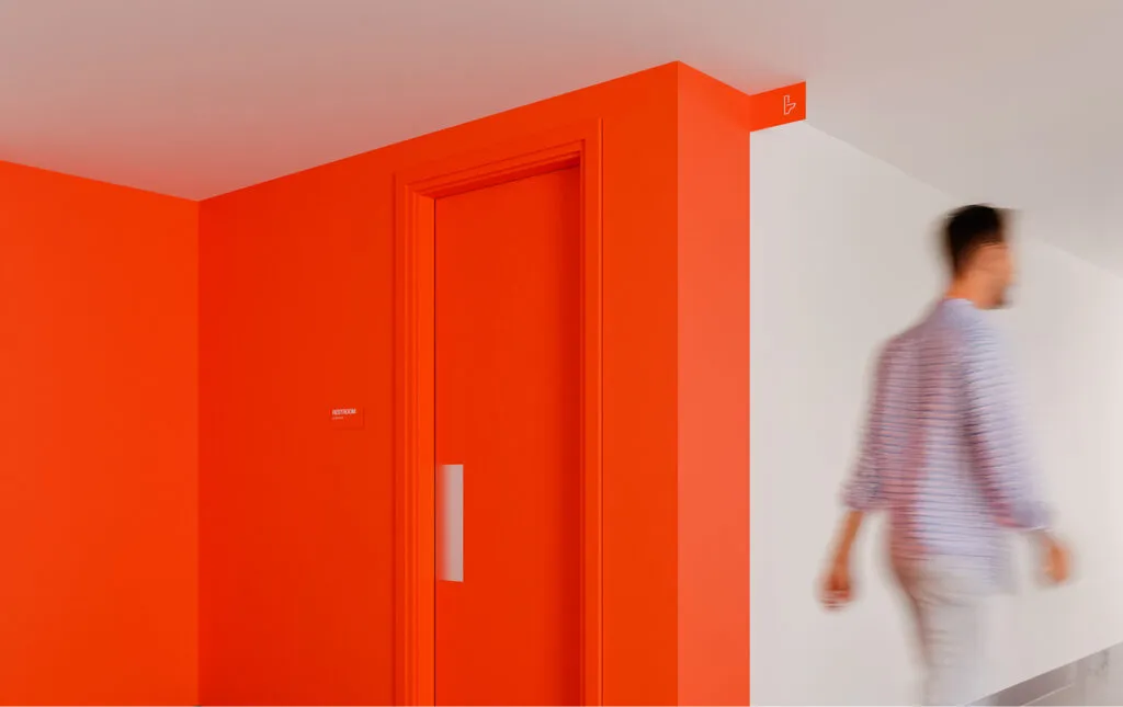 Orange wall painted designating a restroom