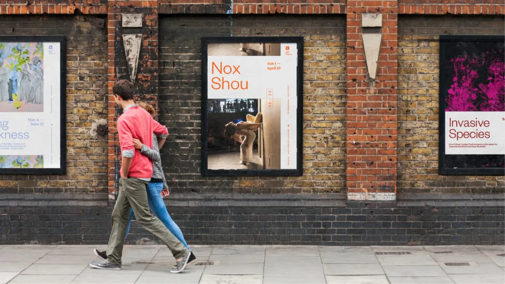 Ads for Asian Arts shows, placed on a brick wall in an urban environment