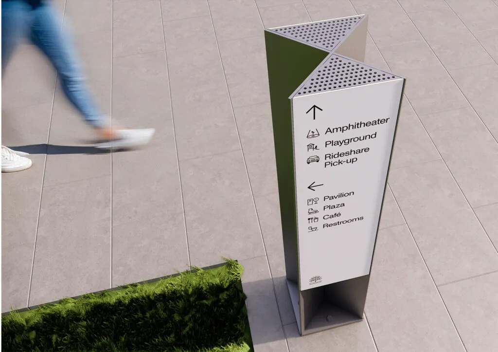 Ground mounted directional sign pointing towards amphitheater and playground