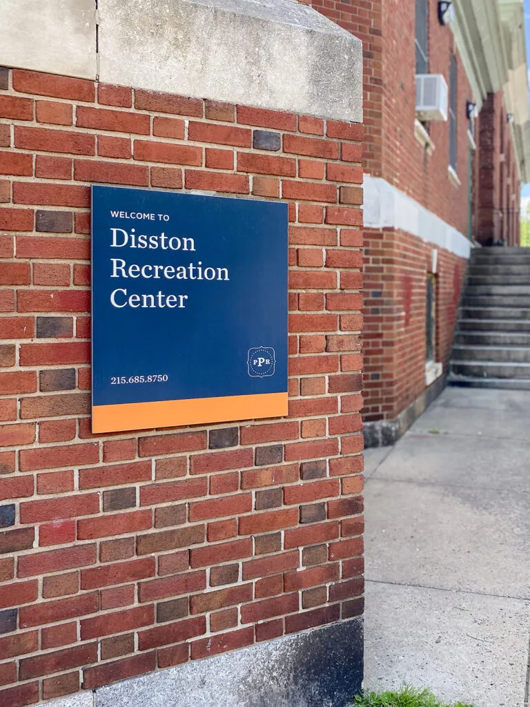 Sign mounted to brick building. Sign reads 