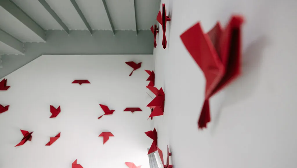 Detail shot of final origami bird, with unfolded paper in the background